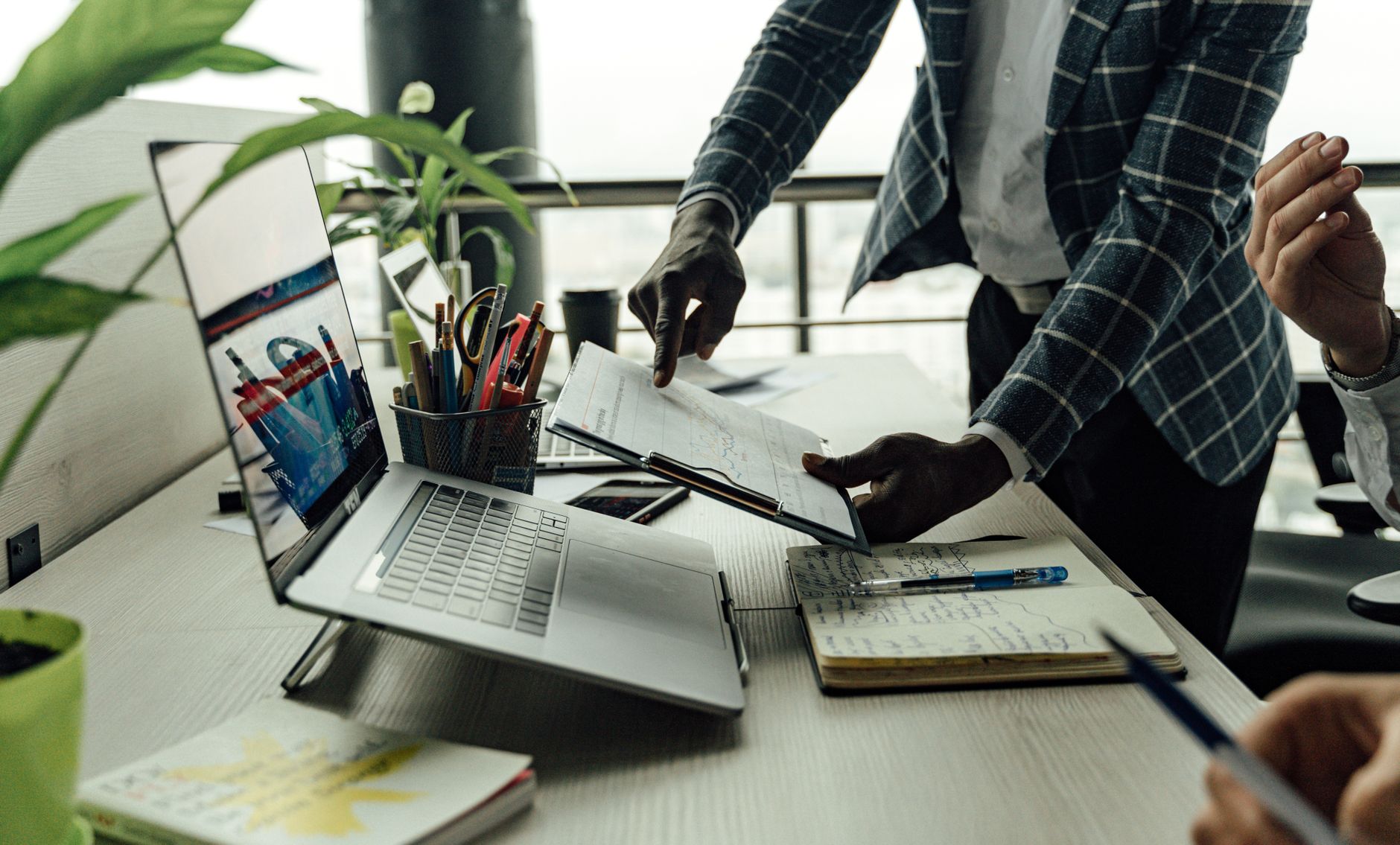 Colleagues collaborating on financial data analysis with a laptop in the office. — 3 Key Advantages of Post-Industrial Plasti