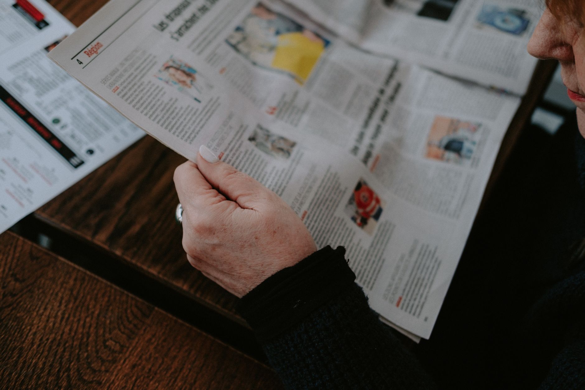 Adult reading a newspaper indoors. Captures focus and interest. — 3 Ways to Buy Term Paper