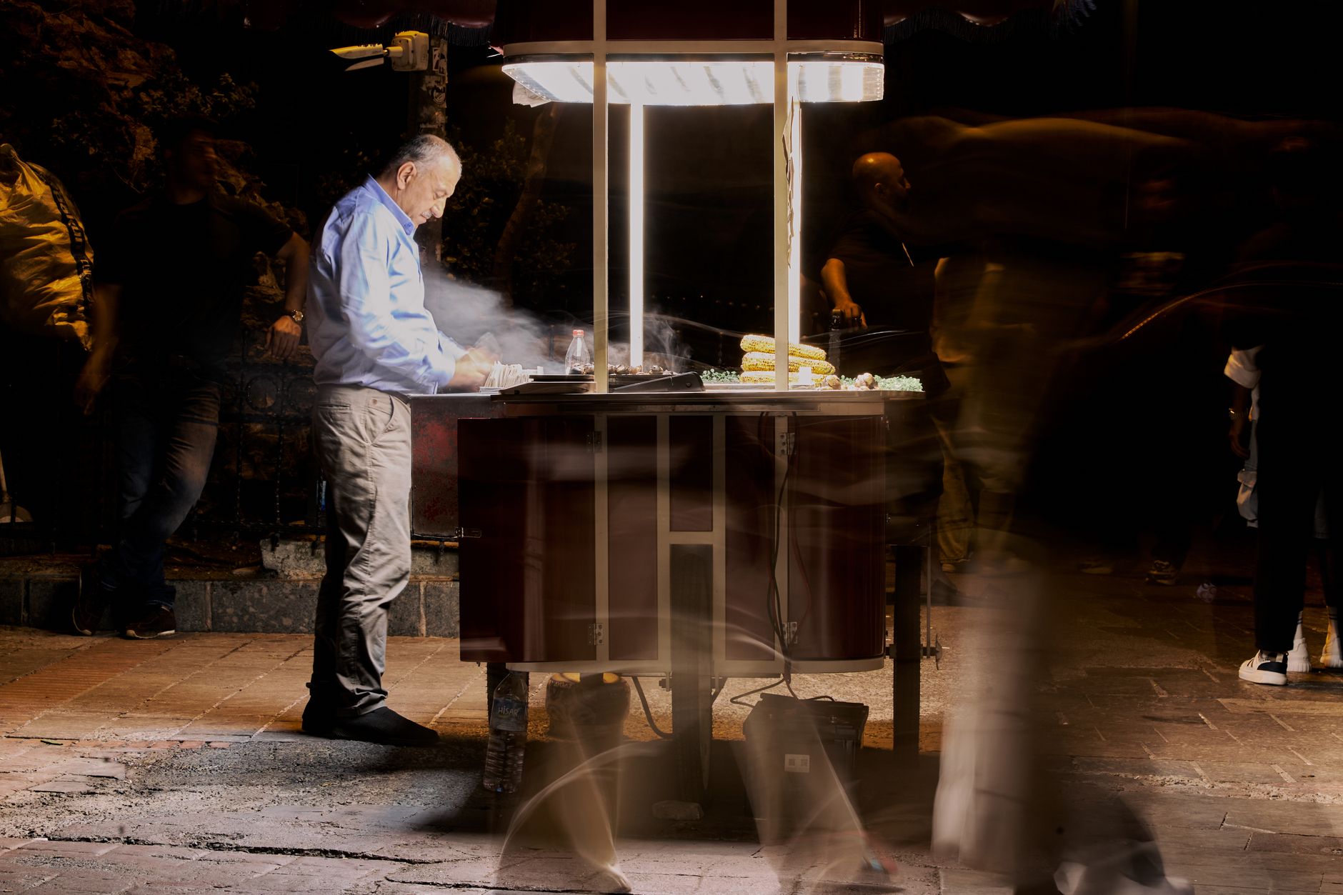 Street vendor cooking food at night with blurred people passing by. — Breaking the Routine with Innovative Work Meetings