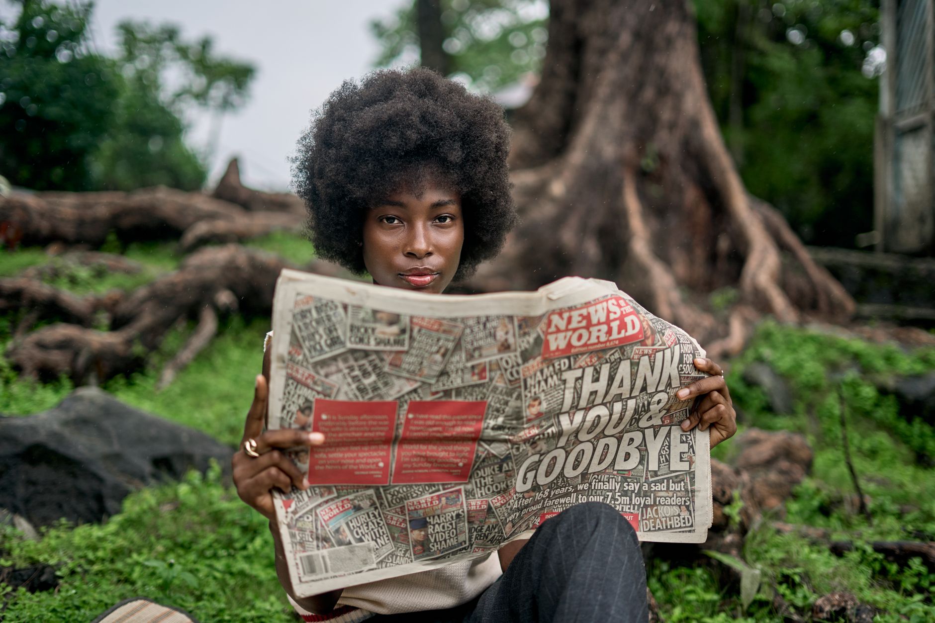A woman enjoys reading a newspaper in a natural outdoor setting, showcasing leisure and nature. — Hard anodized cookware Dati