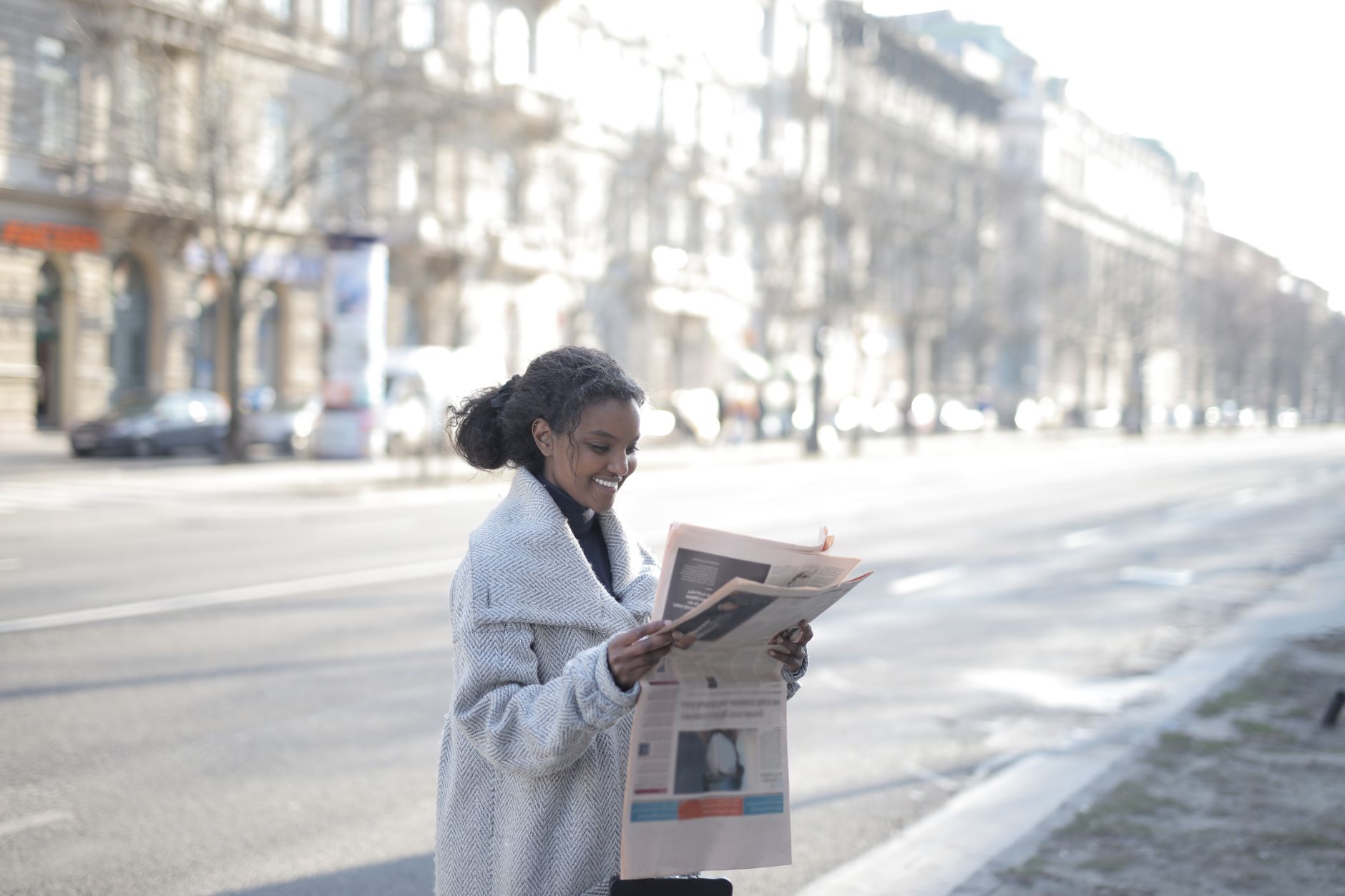 African American woman reading a newspaper on an urban street, enjoying a peaceful morning. — How to Choose the Best Research