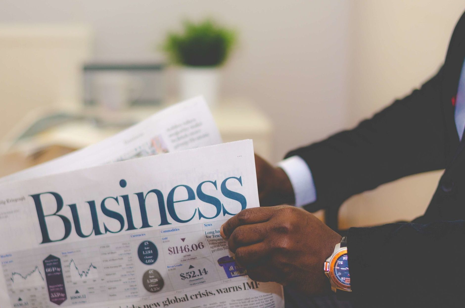 Close-up of a businessman reading a newspaper indoors, focusing on business headlines. — Indiana Squatter Laws Provide Struct
