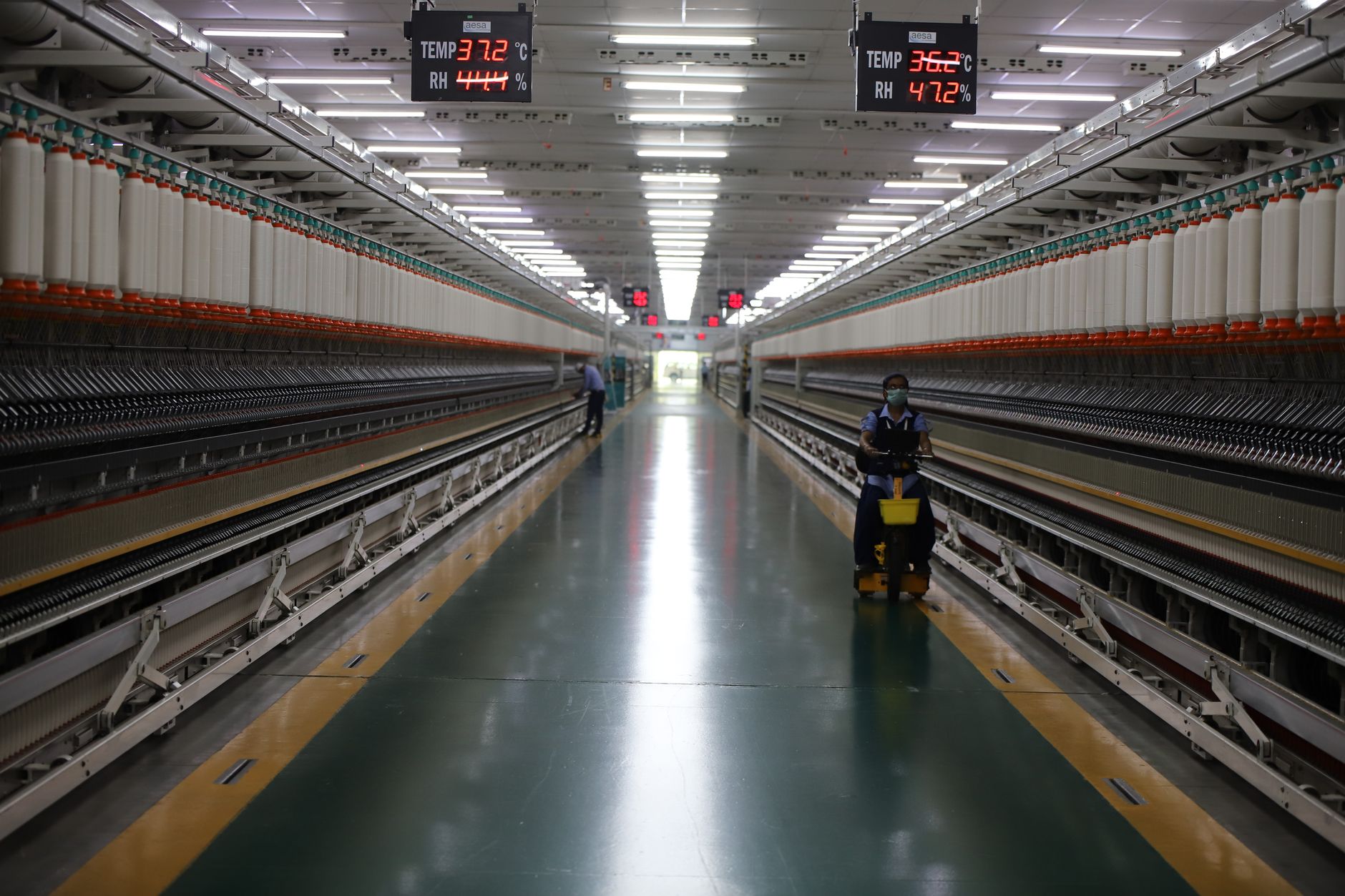 Long hallway in Indian textile factory with spinning machinery and workers. — Is data visualization essential for business or